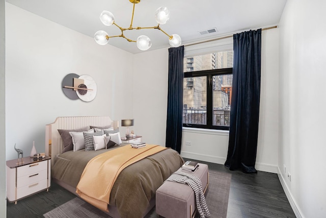 bedroom featuring a notable chandelier and dark hardwood / wood-style flooring