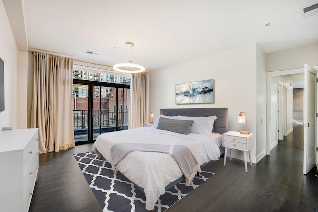 bedroom with access to exterior and dark hardwood / wood-style floors