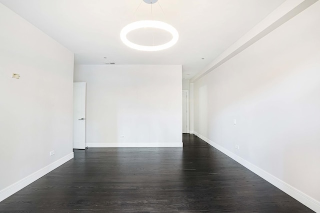 empty room with dark hardwood / wood-style flooring