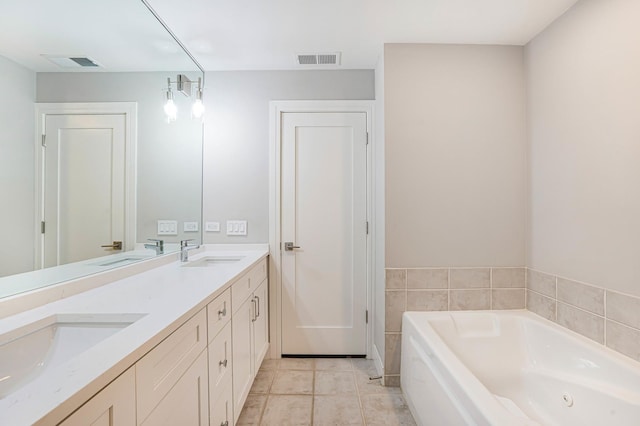 bathroom featuring tile patterned floors, a tub to relax in, and vanity