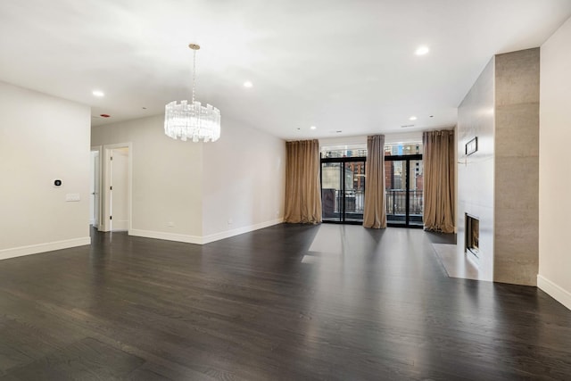 empty room featuring a chandelier and dark wood-type flooring