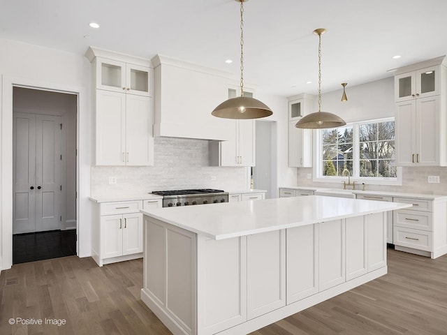 kitchen with white cabinetry, a center island, pendant lighting, and dark hardwood / wood-style floors