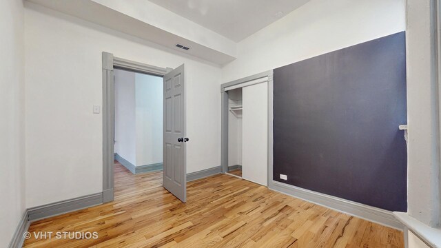 unfurnished bedroom featuring light hardwood / wood-style floors and a closet