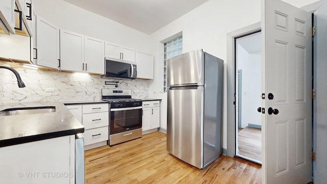 kitchen featuring sink, white cabinets, light hardwood / wood-style floors, and appliances with stainless steel finishes