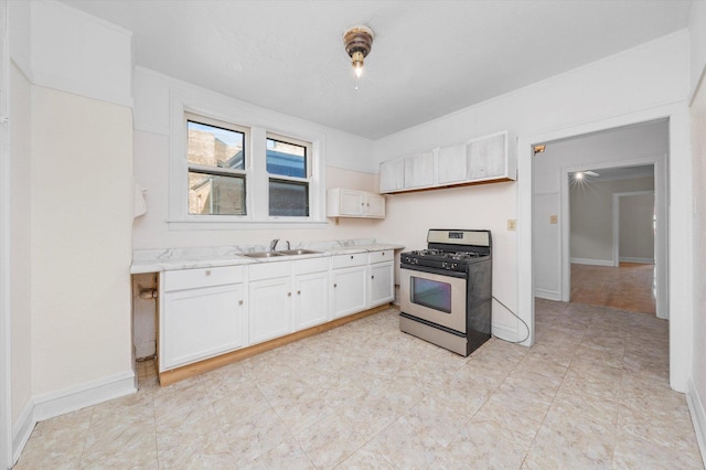 kitchen with sink, white cabinetry, and gas stove