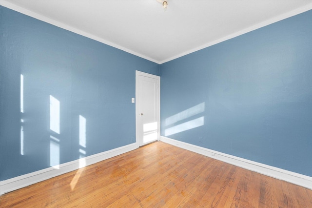 unfurnished room featuring ornamental molding and hardwood / wood-style floors