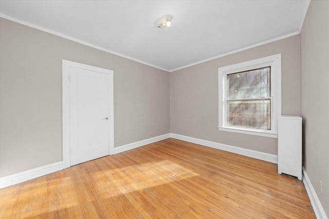 empty room featuring crown molding and light hardwood / wood-style floors