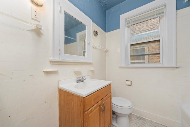 bathroom with toilet, tile patterned floors, and vanity