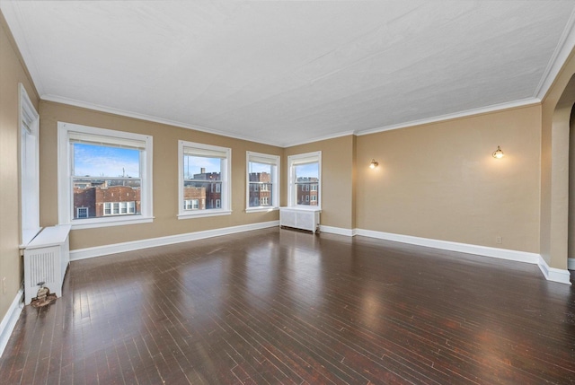 empty room featuring radiator heating unit, crown molding, and dark hardwood / wood-style flooring