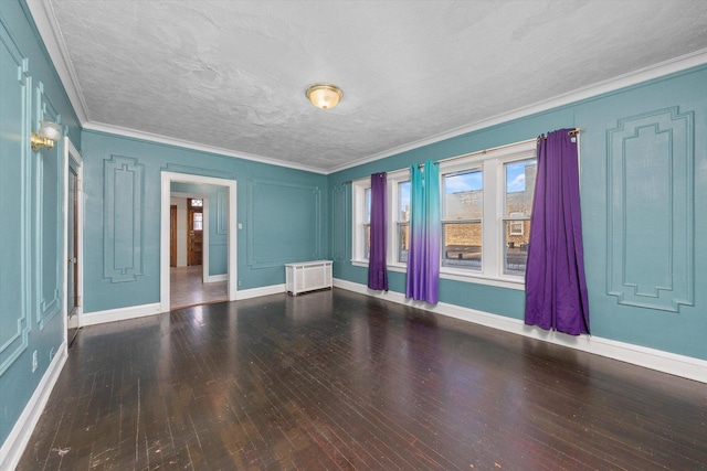 spare room featuring radiator, ornamental molding, a textured ceiling, and wood-type flooring