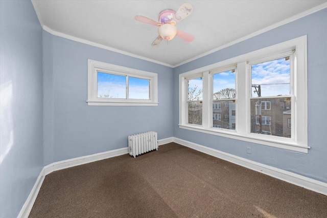 empty room with crown molding, dark colored carpet, radiator, and ceiling fan