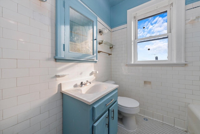 bathroom featuring vanity, toilet, tile walls, and tile patterned flooring