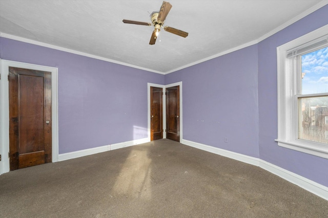 empty room with ceiling fan, carpet, and crown molding