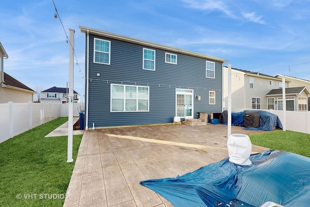 back of house with a patio area and a lawn