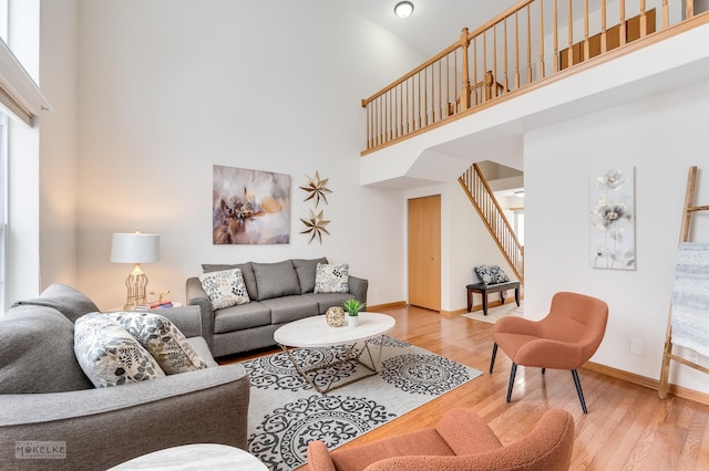 living room featuring a towering ceiling and hardwood / wood-style flooring