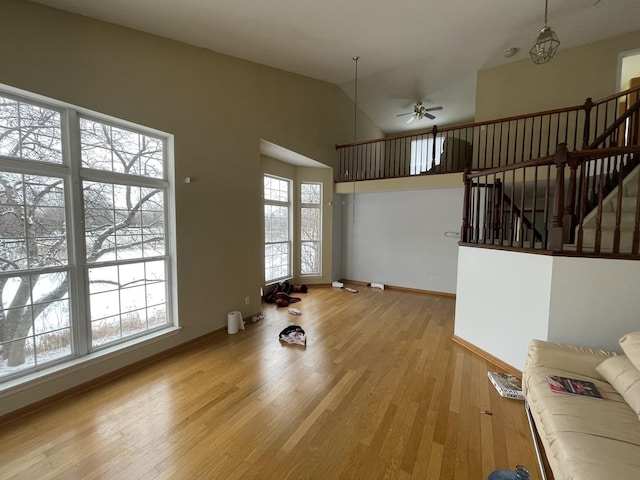 unfurnished living room featuring lofted ceiling, ceiling fan, and light wood-type flooring