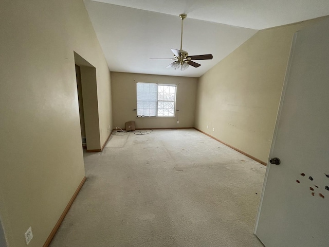 carpeted spare room featuring ceiling fan and lofted ceiling