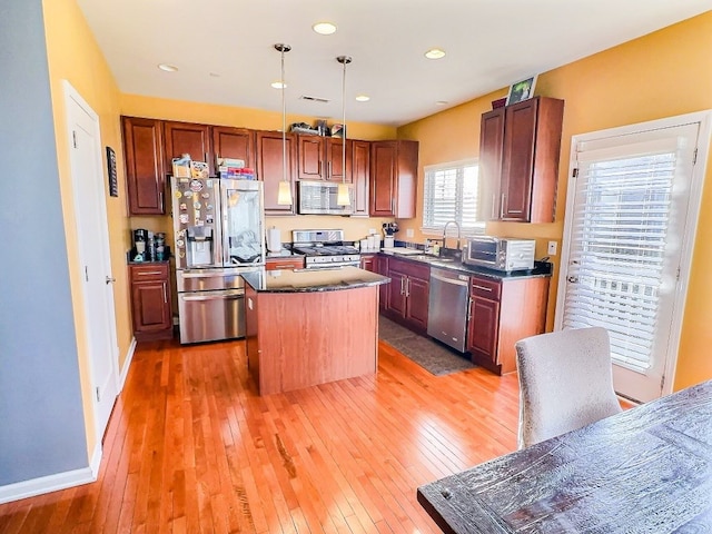 kitchen featuring pendant lighting, dark wood-type flooring, stainless steel appliances, and a kitchen island