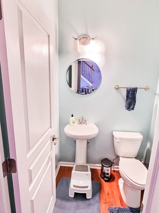 bathroom with toilet and hardwood / wood-style floors