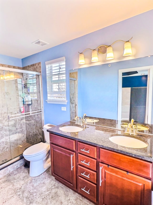 bathroom with a shower with door, vanity, and toilet