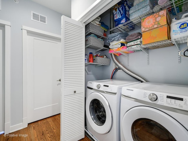 washroom with separate washer and dryer and dark hardwood / wood-style floors