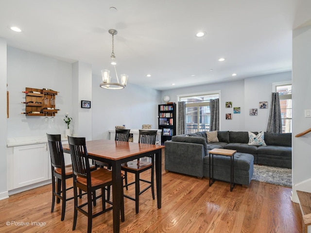 dining space with a healthy amount of sunlight, an inviting chandelier, and light hardwood / wood-style floors