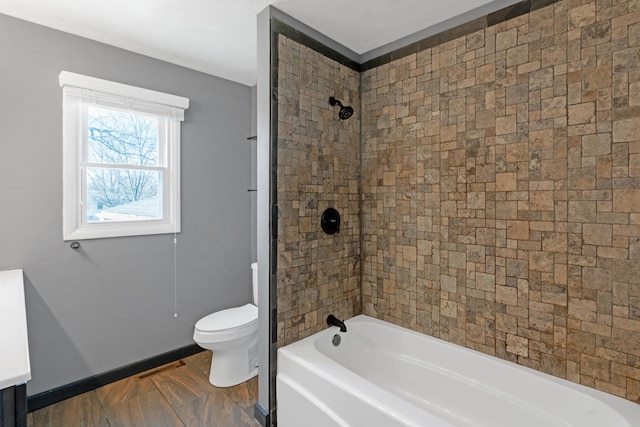 bathroom with tiled shower / bath and toilet