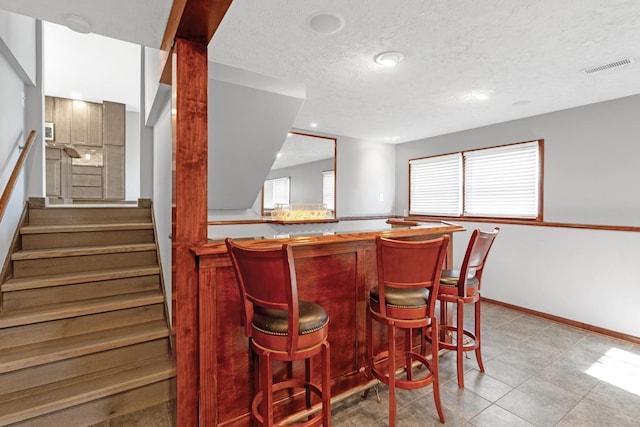 bar featuring a textured ceiling