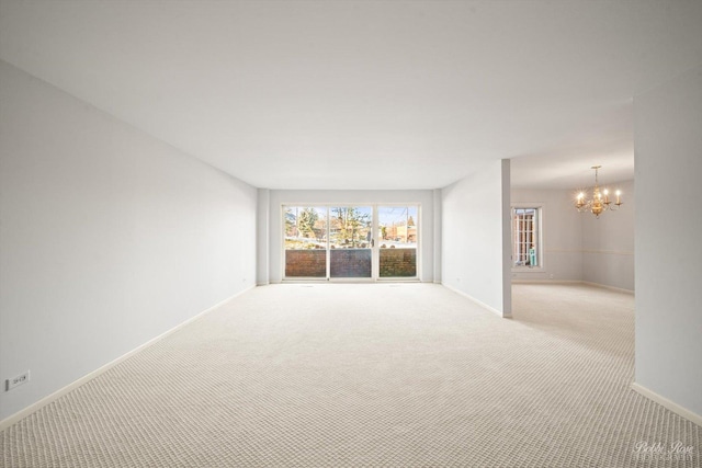 unfurnished room with light colored carpet and a chandelier