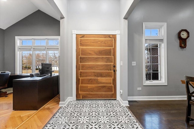 foyer entrance with vaulted ceiling and hardwood / wood-style floors