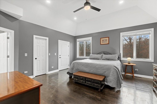 bedroom with multiple windows, dark wood-type flooring, vaulted ceiling, and ceiling fan