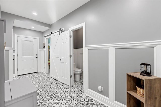 corridor with light tile patterned flooring and a barn door