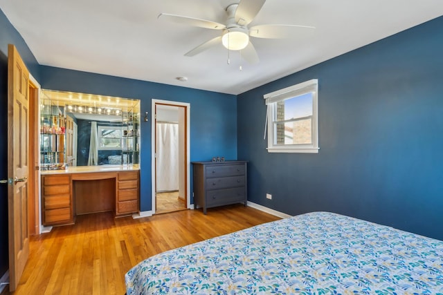 bedroom featuring ceiling fan, built in desk, and light hardwood / wood-style flooring