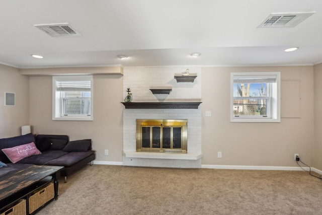 carpeted living room with a brick fireplace, crown molding, and plenty of natural light