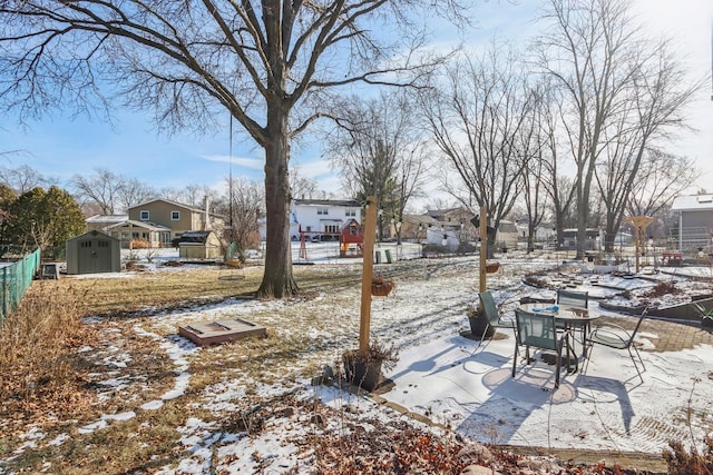 yard covered in snow with a shed