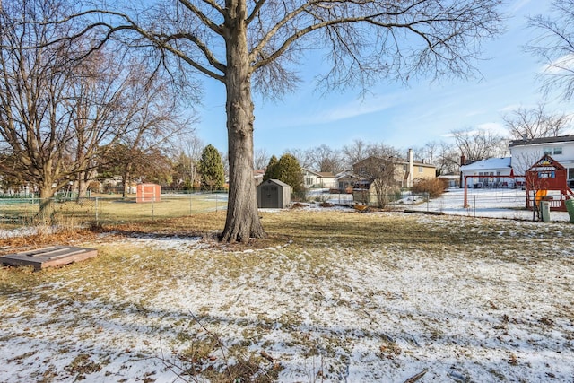 yard layered in snow with a storage unit