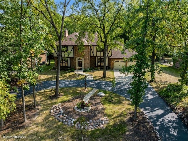 tudor house with a garage and a front lawn