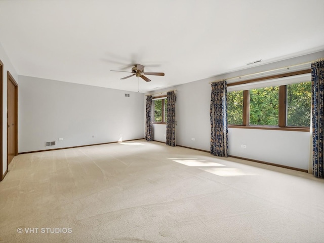 unfurnished room with light carpet, plenty of natural light, and ceiling fan