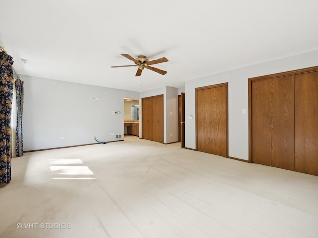 unfurnished bedroom with light carpet, connected bathroom, and ceiling fan