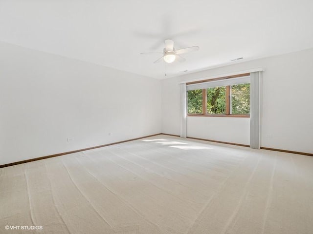 spare room with ceiling fan and light colored carpet