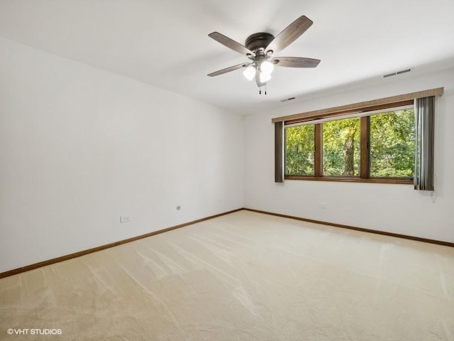 carpeted spare room featuring ceiling fan