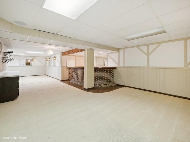 basement featuring carpet and a paneled ceiling