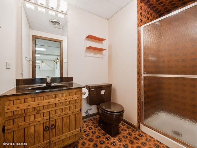 bathroom featuring a shower with shower door, toilet, and vanity