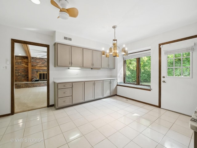 kitchen featuring decorative light fixtures, ceiling fan with notable chandelier, light tile patterned floors, and a fireplace