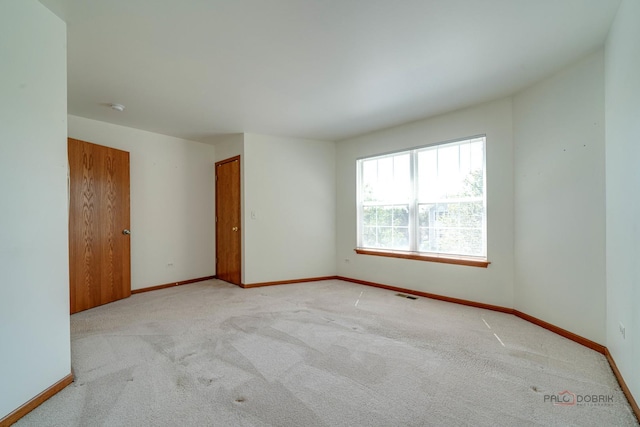 unfurnished room featuring light carpet