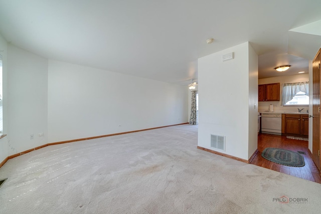 unfurnished living room featuring sink, ceiling fan, and carpet