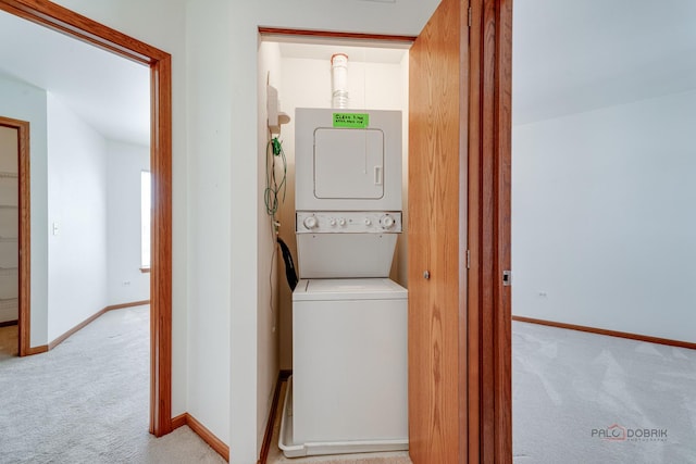 laundry area with light colored carpet and stacked washer / dryer