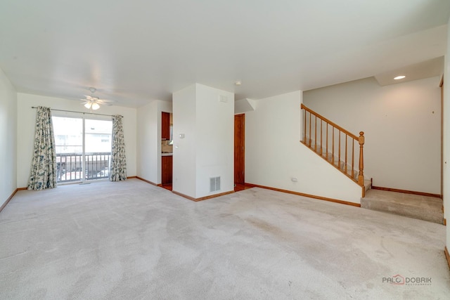 unfurnished living room with light colored carpet and ceiling fan