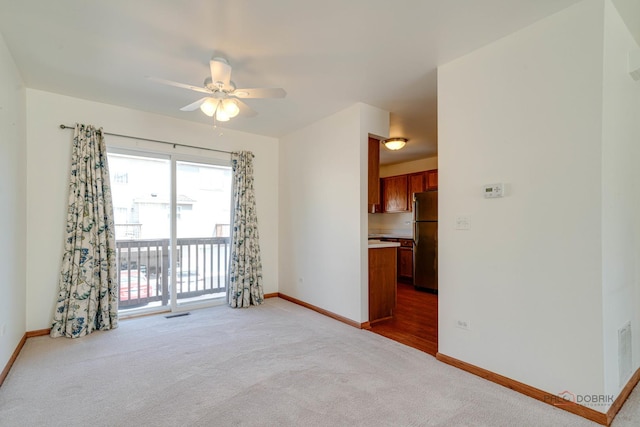 unfurnished room featuring ceiling fan and light carpet