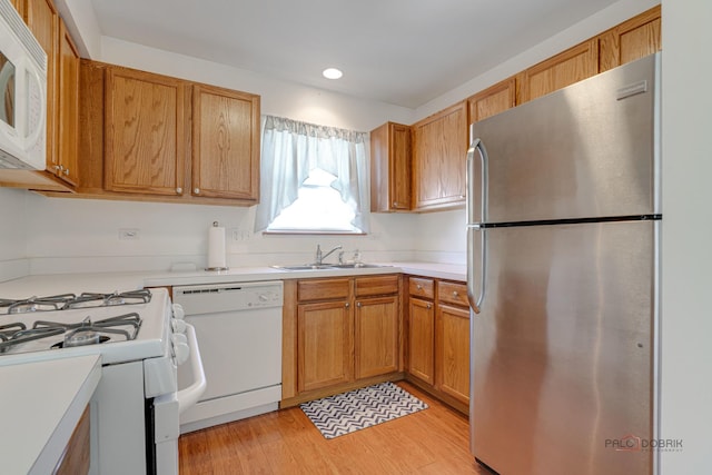 kitchen featuring sink, white appliances, and light hardwood / wood-style floors